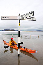 Kayakers in the flood waters on the road at Storth, Kent Estuary in Cumbria, UK, during the January 2014 storm surge and high tides. January 2014