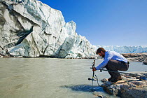 Scientist taking measurements as part of a study to measure the speed of the Russell Glacier near Kangerlussuag, Greenland. July 2008