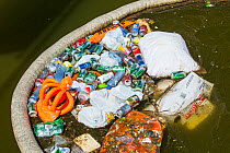 Rubbish up against a litter trap on a canal in Amsterdam, Netherlands. May 2013