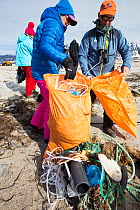 Tourists collect plastic rubbish on a remote beach in Northern Svalbard, only about 600 miles from the North Pole. The plastic has been washed ashore from the sea by ocean currents. July 2013