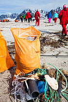Tourists collect plastic rubbish on a remote beach in Northern Svalbard, only about 600 miles from the North Pole. The plastic has been washed ashore from the sea by ocean currents. July 2013