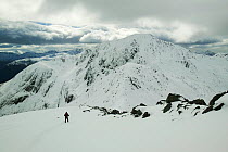 Winter climber ascends An Garbhanach in the Mamore hills, Scotland, UK.  March 2004