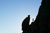 Climber silhouetted by the Spinx rock on Great Gable in the Lake District, England, UK. July 2005