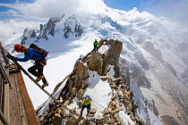 Mont Blanc from the Aiguille Du Midi above Chamonix, France, with climbers on the Cosmiques Arete, climbing the ladder to access the cable car station. September 2014