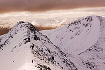Winter climber ascends An Garbhanach,  Mamore hills Scotland, UK. March 2004