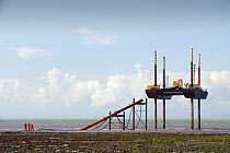 Jack up barge working on the foreshore of the Solway Firth near Workington, installing the power cable that will carry the electricity from the new Robin Rigg offshore wind farm. Solway Firth, Scotlan...