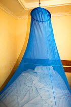 A mosquito net over a bed in a bedroom in a cheap hotel in Chikwawa, Malawi. March 2015.