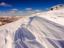 Snow shaped by a strong wind, above Wrynose Pass in the Lake District, Cumbria, UK. April 2013.