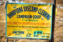 Annapurna base camp at 4130 metres in front of Annapurna South summit, , with a sign about a cleanup campaign. Annapurna Sanctuary, Himalayas, Nepal. December 2012.