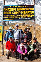 Trekking group at Annapurna base camp at 4130 metres in front of Annapurna South summit, Annapurna Sanctuary, Himalayas, Nepal. December 2012.