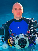Portrait of photographer Alex Mustard with underwater photography equipment. Small repro only.