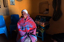 Local woman wrapped in traditional Basotho blanket in her home in Semonkong, Lesotho. August 2017