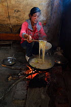 Chinese woman cooking, Xiang Bai Lisu village, Tongbiguan Nature Reserve, Dehong prefecture, Yunnan province, China. May