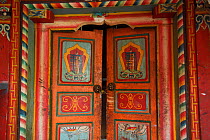 Decorated door entrance to a building at Lower Yubeng village, Meili Snow Mountain National park, Yunnan, China, October 2017.