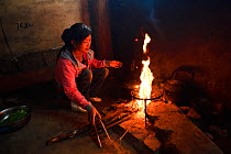 Woman cooking,  Xiang Bai Lisu village, Tongbiguan Nature Reserve, Dehong prefecture, Yunnan province, China, May.