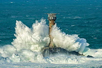 Waves crashing against Longships Lighthouse, Land's End, Cornwall, England, UK. February 2015.