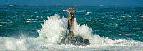 Waves crashing against Longships Lighthouse, Land's End, Cornwall, England, UK. February 2015.