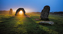 Sunrise through stone at Men-An-Tol, Morvah, Cornwall, England, UK. September 2016.