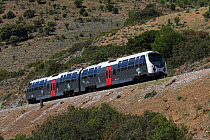 The Trinicellu train running along a hillside on a metre gauge track  in Corsica, France, May 2017