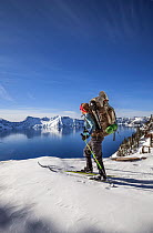 Woman cross country skiing along the north side of Rim Drive in Crater Lake National Park. Oregon, USA. Model released,
