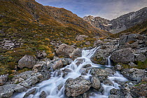 Looking up Otira Valley with Otira River in the foreground. Slow shutter speed showing movement of the water. Arthur's Pass National Park, Southern Alps, New Zealand. May.