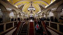 Commuters using escalators in Moscow's Komsomolskaya metro station, showing vaulted ceiling and chandeliers, Russia, May 2016. Hellier
