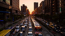 Timelapse of the sun setting at the end of a street at rush hour, Taipei, Taiwan, March 2018. Hellier