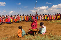 Maasai children watch woman singing traditional song, Maasai village, Kenya. September 2006.