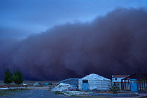 Sand storm rolling in over lodges on farm, Inner Mongolia, China