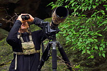 Wildlife photographer Jed Weingarten watching wildlife through binoculars, Tangjiahe National Nature Reserve, Qingchuan County, Sichuan province, China