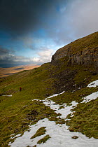 A walker on the Western slopes of Pen-y-ghent, one of the Yorkshire &#39;3 Peaks&#39;. Horton-in-Ribblesdale, Yorkshire, England. February 18.
