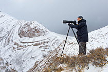 Photographer Axel Gomille, tracking and photographing snow leopards (Panthera uncia), Himalaya, Hemis National Park, Ladakh, India. February 2014.