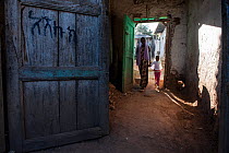 Woman and girl walking through passageway, Harar, Ethiopia. February 2008.