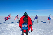 Wildlife photographer Sue Flood at ceremonial South Pole 90 degrees South near Scott-Amundsen, Antarctica. December 2016