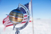 Marker to show geographical South Pole 90 degrees South with USA flag, near Scott-Amundsen base, Antarctica.December 2016