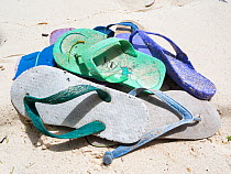 Discarded plastic flip-flops shoes on beach. Palau, Caroline Islands, Philippine Sea, Pacific Ocean. December 2013.