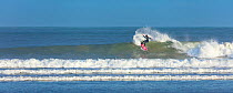 Man surfing in Cantabrian Sea, La Salve beach, Santona, Victoria and Joyel Marshes Natural Park, Laredo, Cantabria, Spain. January 2018.