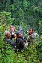 Three photographers photographing gibbons in Wuliangshan Nature Reserve, Jingdong, Yunnan Province, China. October 2017.