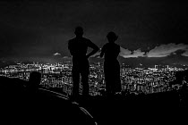 Silhouette of man and woman looking out over Hong Kong from Victoria Peak, Hong Kong Island, China. June, 2016.
