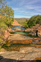 People swimming in freshwater pools on Waterfall Creek, at the top of Gunlom Falls. Mary River, Kakadu National Park, Northern Territory, Australia. March 2014.