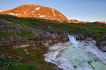 Waterfall in the Skavldalselva river with white marble riverbed.. Lahko National Park, Fjell, Norway, July.