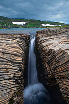 Marble formations with waterfall on a lake shore. Lahko National Park, Fjell, Norway, July.