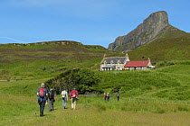 Walkers on the isle of Eigg, in the Small Isles, Scotland. July 2017.