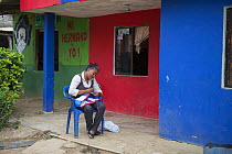 Woman making &#39;eco-mochila&#39; bag from recycled plastic bags. Bags are sold to raise money for Proyecto Titi, funding Cotton-top tamarin (Saguinus oedipus) conservation. Los Limites, Colombia. Ju...