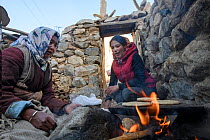 Women baking kulcha (flat bread) on traditional open fire in an ecotourism lodge. Part of a broader eco tourism initiative to augment their income and change local attitudes towards snow leopards (Pan...