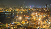 Timelapse from day to night looking over Tsing Yi container port, with cranes filling container ships, Hong Kong, China, 2017.