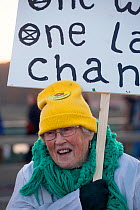 Woman holding placard during Extinction Rebellion demonstration. Five bridges across the Thames were blocked to draw attention to climate change. Westminster, London, England, UK. November 2018.