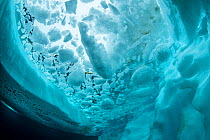 View up to sea surface between ice and iceberg. Tasiilaq, East Greenland. April.