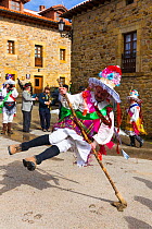 Man leaping over stick in traiditional costume, Carnival of Zamarrones, Pejanda village, Polaciones valley, Cantabria, Spain. February 2013.