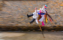 Man leaping over stick in traiditional costume, Carnival of Zamarrones, Pejanda village, Polaciones valley, Cantabria, Spain.